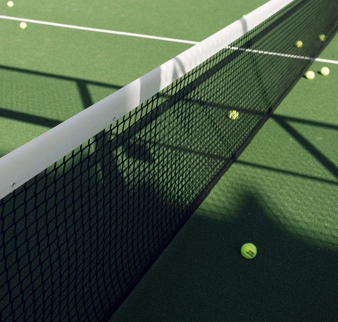 Close-up of a padel net with balls scattered on the court at the ReServe padel facility at The Seagate Delray Racquet Club