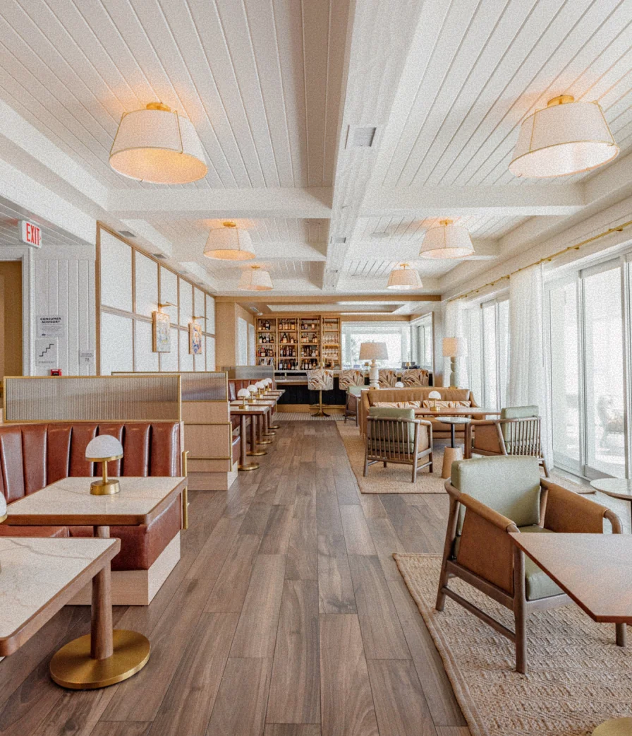Interior of the private upstairs member lounge at The Seagate Beach Club with bar seating and ocean-view windows