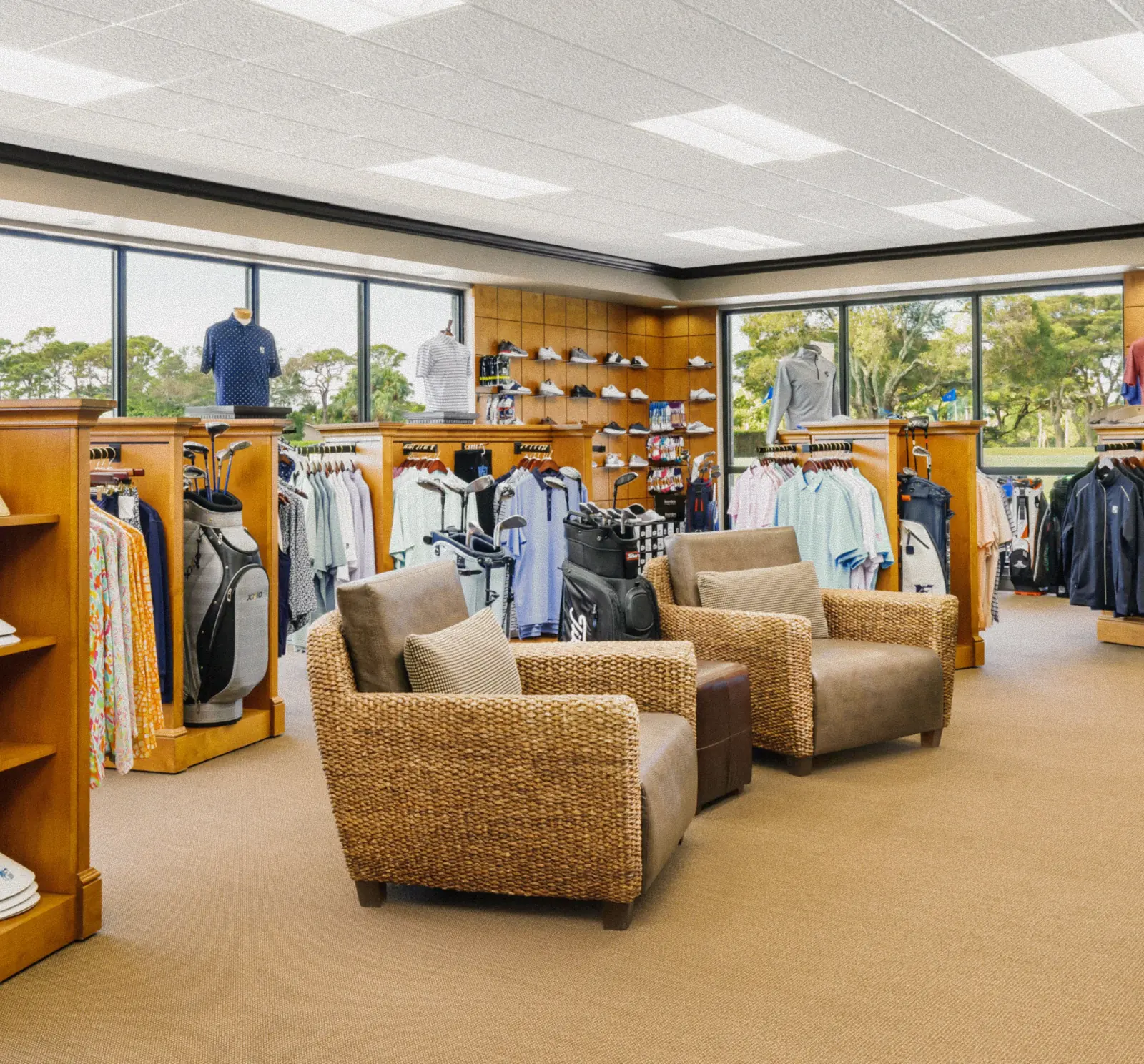Interior of the pro shop at The Seagate Golf Club showing apparel racks, golf bags, and wicker lounge seating