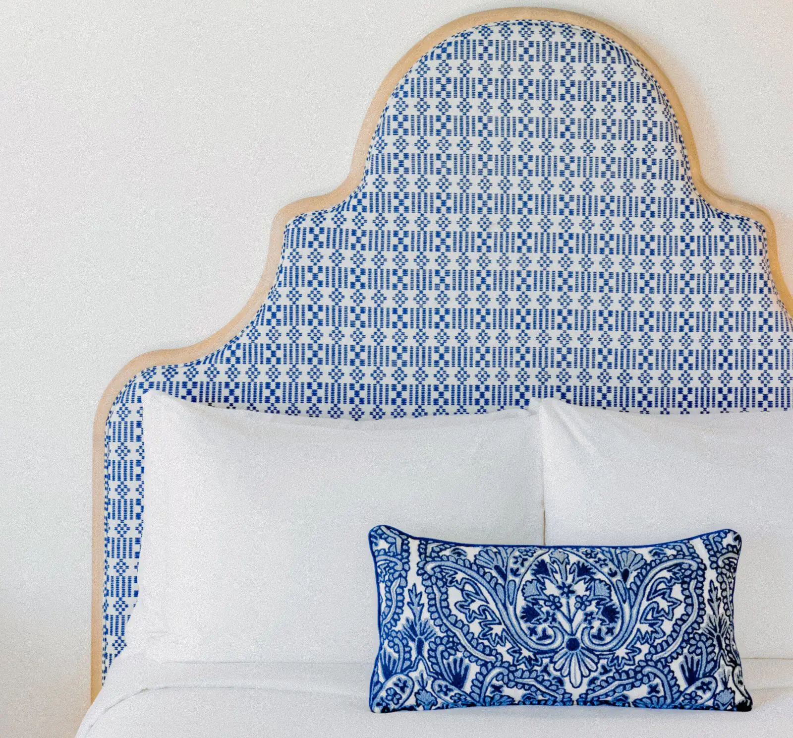Patterned blue and white headboard with decorative pillow in a Seagate Hotel room, available to members and hotel guests