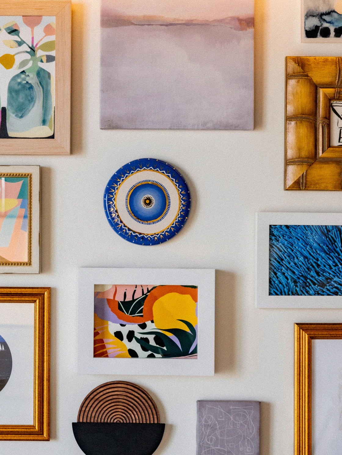 Gallery wall of colorful framed artwork and decorative objects in a guest room at The Seagate Hotel