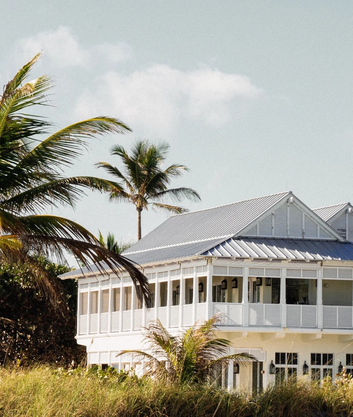 Street-level exterior view of The Seagate Hotel Beach Club building surrounded by palm trees