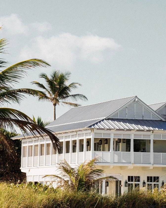 Street-level exterior view of The Seagate Hotel Beach Club building surrounded by palm trees