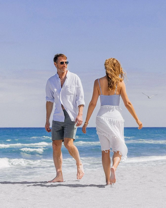 A couple walking hand-in-hand along the shoreline on the private member beach at The Seagate in Delray Beach